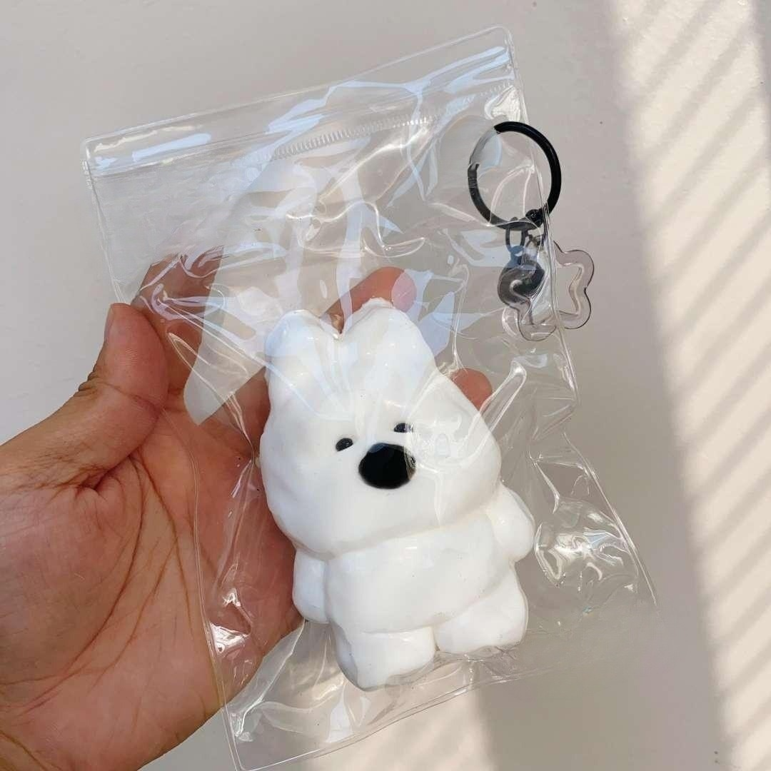 Cloud Pup taba squishy inside a clear bag, perfectly showcasing its white, Westie-inspired shape and charming details.