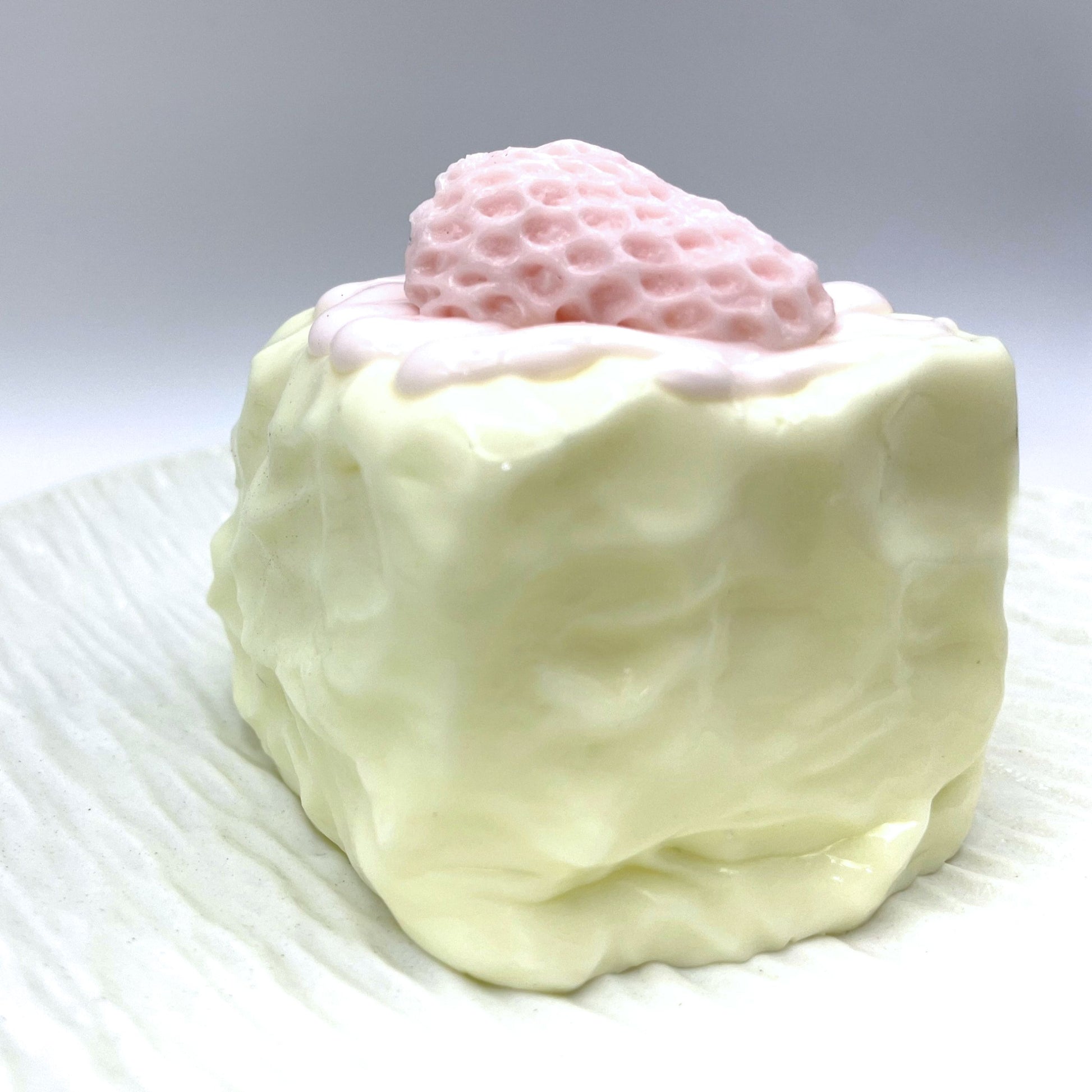 Close-up of the Cream Berry Cube Taba Squishy, highlighting its creamy white color and detailed strawberry decoration.