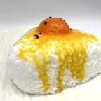 Close-up shot of the Egg Yolk Rice Ball Taba Squishy, focusing on the detailed texture and vivid colors