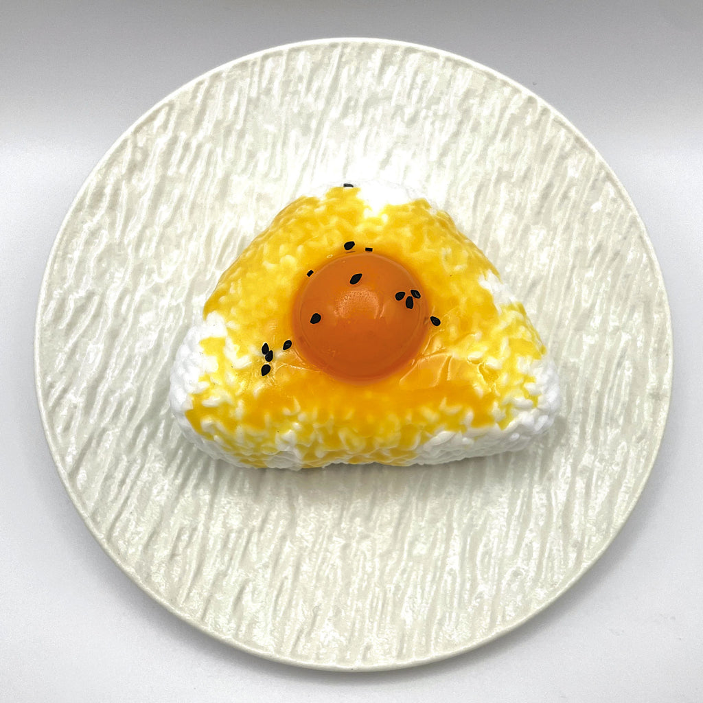 Top view of the Egg Yolk Rice Ball Taba Squishy highlighting the rice ball shape and bright yolk color