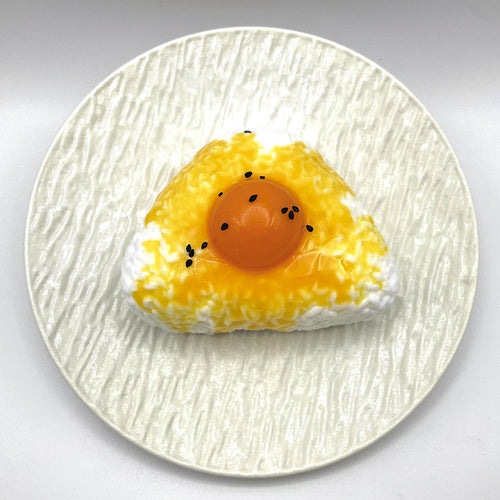 Top view of the Egg Yolk Rice Ball Taba Squishy highlighting the rice ball shape and bright yolk color