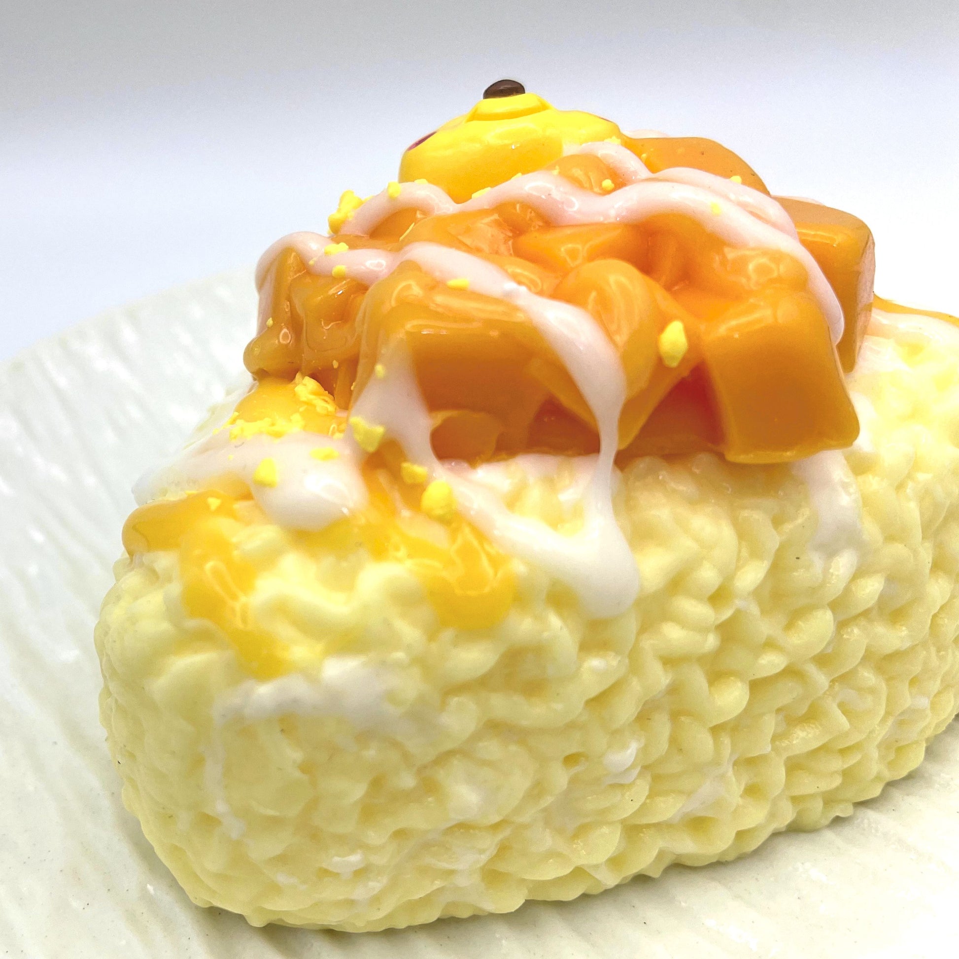 Close-up of the Mango Rice Ball Taba Squishy, highlighting its textured details and glossy mango finish