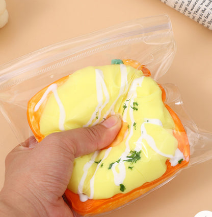 Hand squeezing the Not a Pineapple Toast Taba Squishy, showcasing its soft and stress-relieving texture.