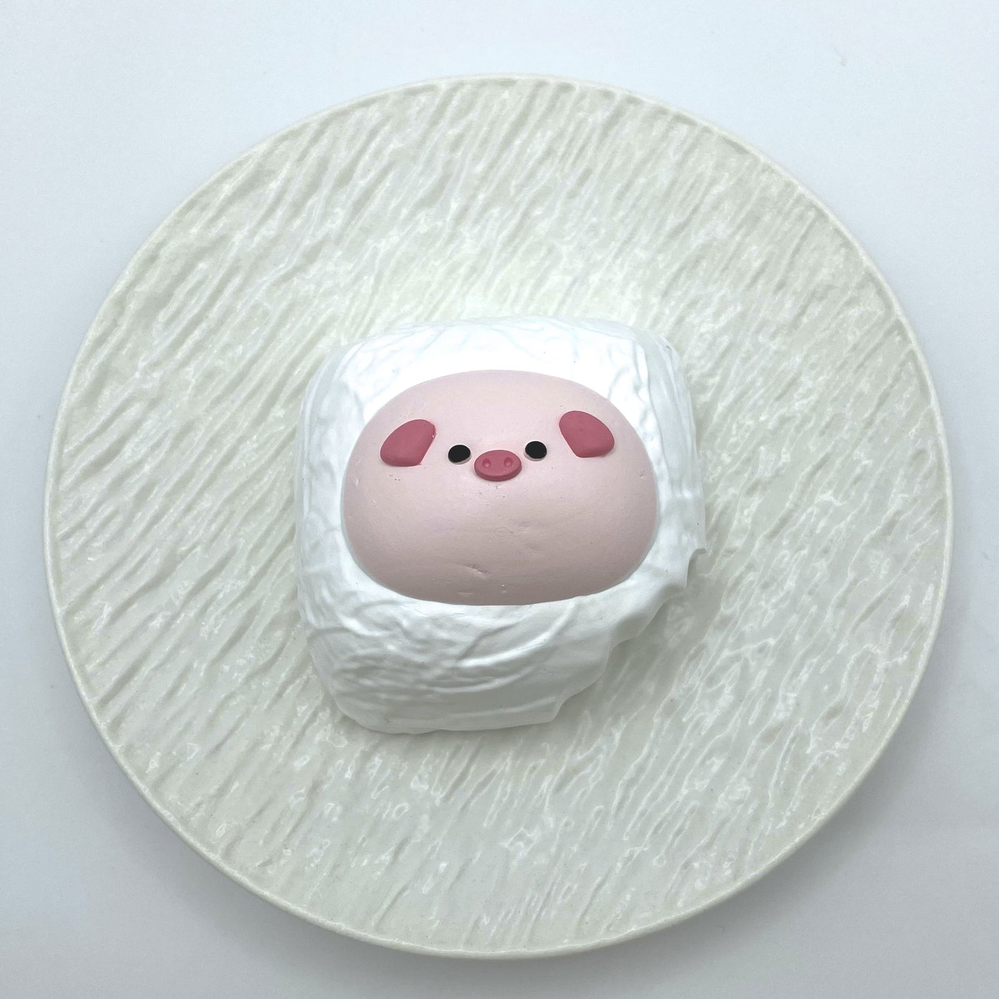 Top view of Piggy Bite Taba Squishy, highlighting its unique square shape with a bitten corner and adorable pig head.