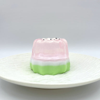 Sparkling Melon Canelé Taba Squishy in a delicate blend of translucent pink and green, featuring a subtle shimmer for a charming and calming effect