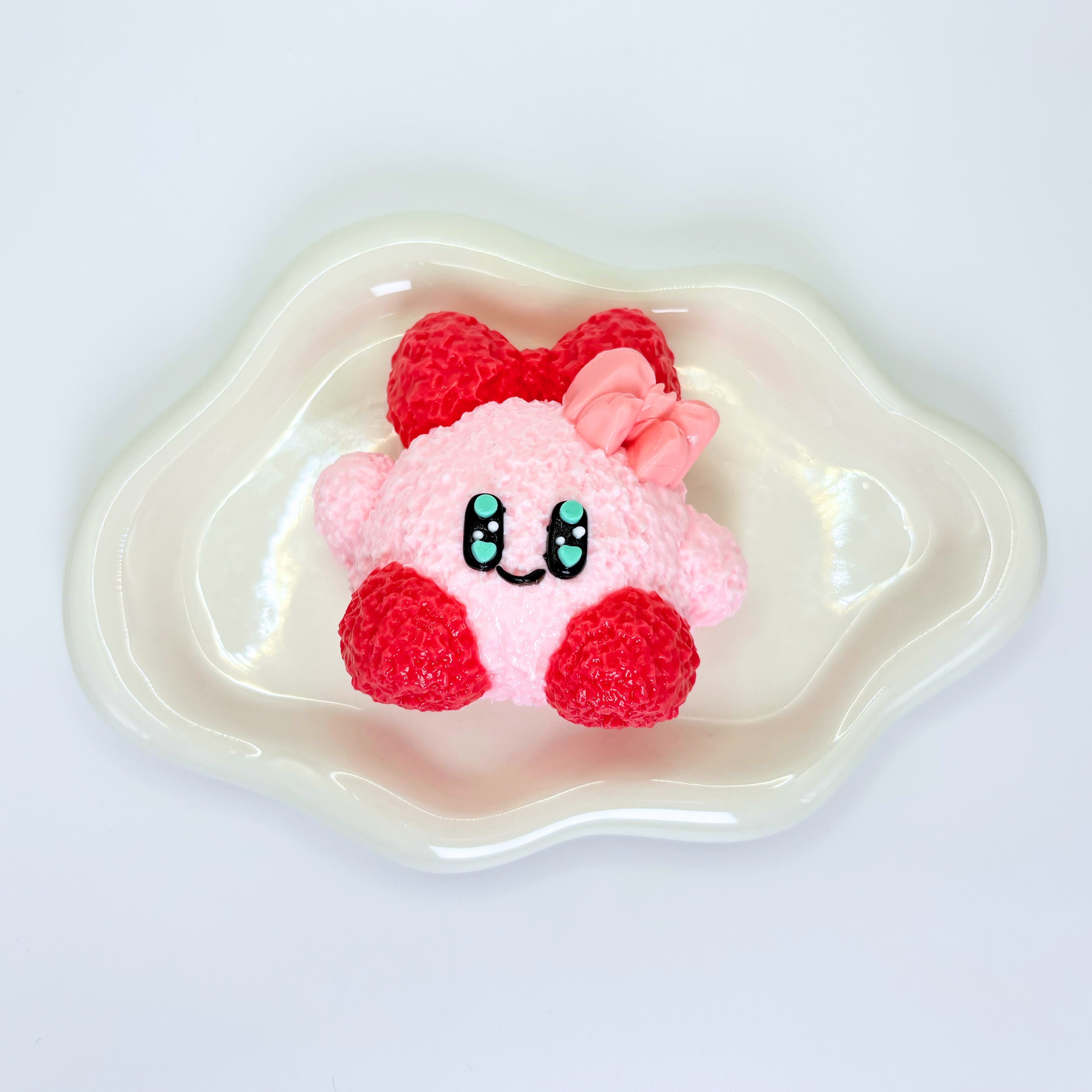 Pink round Kirby-inspired Taba squishy with cute facial features.