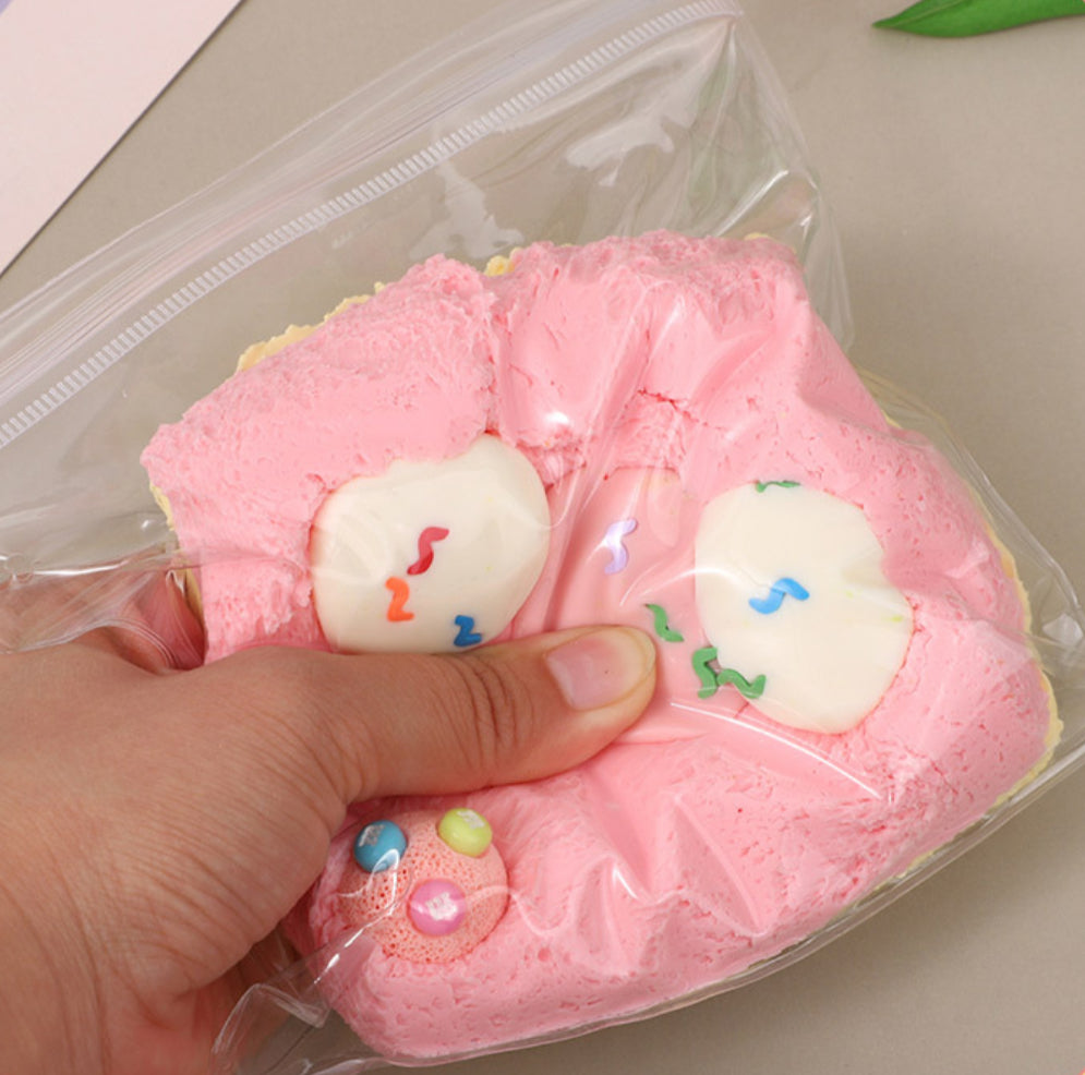 Hand squeezing the Not a cake Taba Squishy, showcasing its soft and stress-relieving texture.